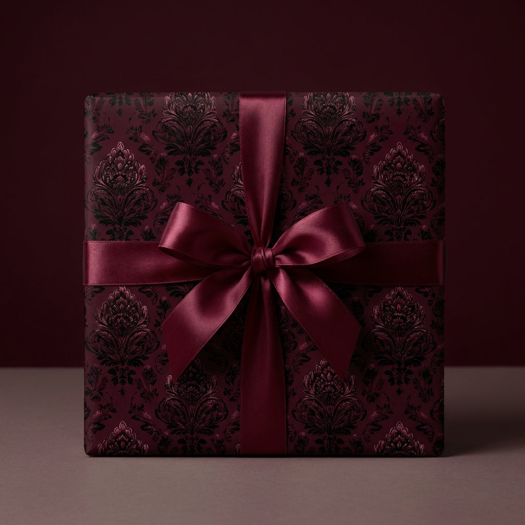 Burgundy gift box wrapped in luxury damask wrapping paper with a satin ribbon bow.