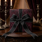 Elegant gift box wrapped in purple damask wrapping paper with a black and silver ribbon.