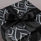 Elegant black gift box with modern silver leaf design and classic satin ribbon bow.