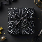 Elegant black gift wrap with silver ribbon and abstract floral pattern, perfect for luxury gifts.