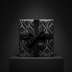 Elegant gift with black ribbon and abstract silver pattern wrapping paper for luxurious present packaging.