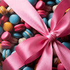 Pastel macarons in a clear gift box tied with a bright pink satin ribbon.