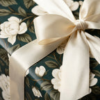 Elegant dark green floral wrapping paper with cream roses and ivory satin ribbon by Wrapped Studios.