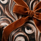 Luxury brown marble wrapping paper with a rust velvet bow by Wrapped Studios.