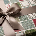 Rustic stone tile wrapping paper with a brown satin bow, luxury gift wrap by Wrapped Studios.