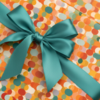 Confetti print birthday wrapping paper with teal satin ribbon and bow.