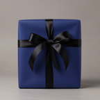 Elegant gift box wrapped in navy blue paper and tied with a glossy black satin ribbon bow.