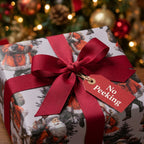Vintage Santa Christmas wrapping paper with a red bow and 'No Peeking' tag by Wrapped Studios.