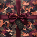 Luxury gift wrap with abstract camo pattern and burgundy satin ribbon bow.