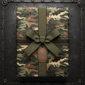 Camouflage gift wrapping paper with olive ribbon, decorative cord, and metal tag.