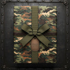 Camouflage gift wrapping paper with olive ribbon, decorative cord, and metal tag.