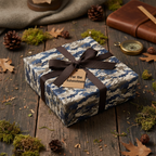 Gift wrapped in blue camo wrapping paper with brown ribbon, perfect adventurer birthday present.