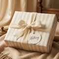 Luxury cream striped wrapping paper with a velvet ribbon and bow by Wrapped Studios.