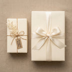 Minimalist cream pinstripe gift wrap with elegant satin bow and rustic twine tag by Wrapped Studios.