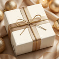 Elegant cream pinstripe wrapping paper with gold ribbon for luxury holiday gifts by Wrapped Studios.
