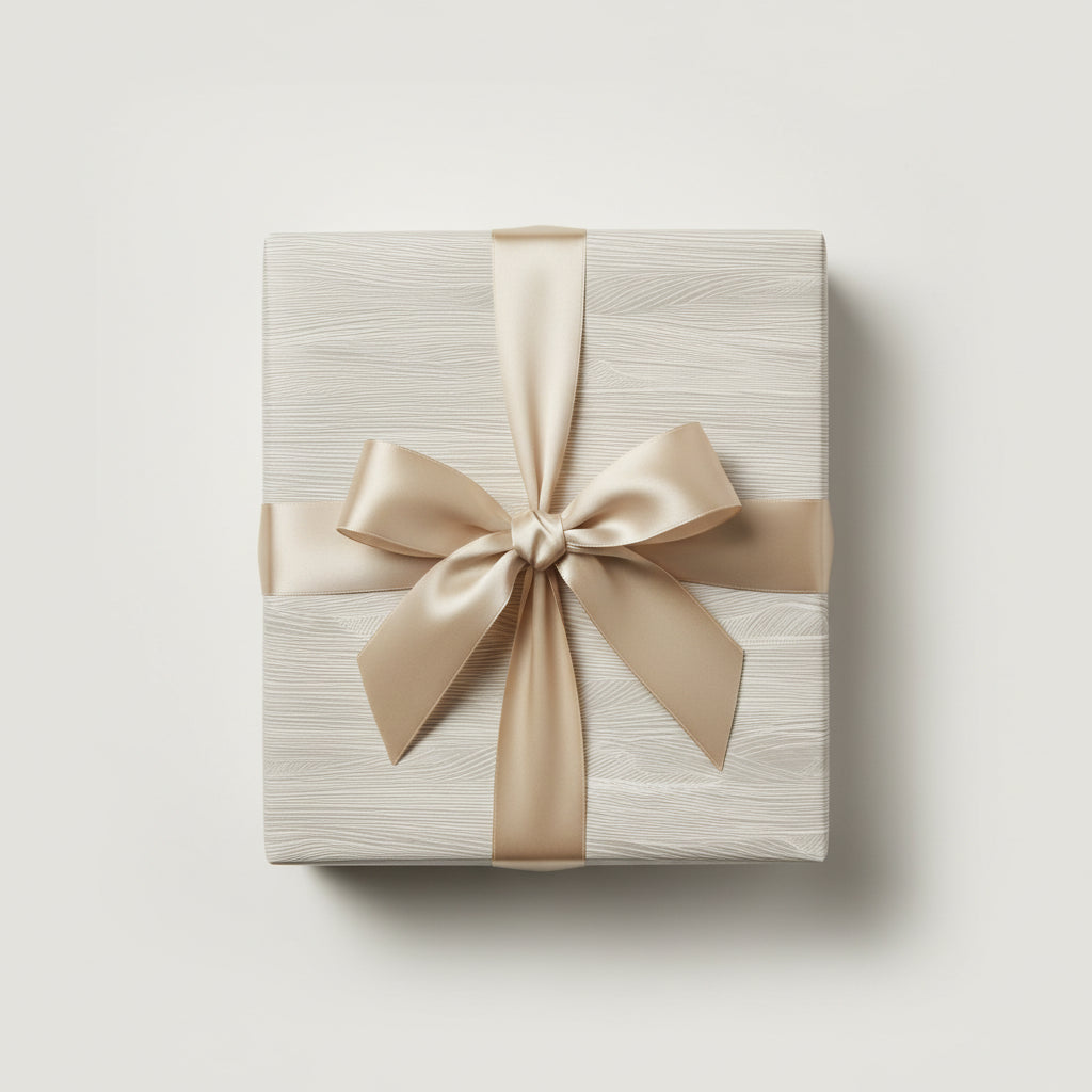 Elegant gift box wrapped in minimalist light gray woodgrain paper with a gold satin ribbon.