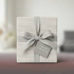 Elegant gift wrapped in minimalist wrapping paper with a soft grey ribbon and a tag saying "A special something".