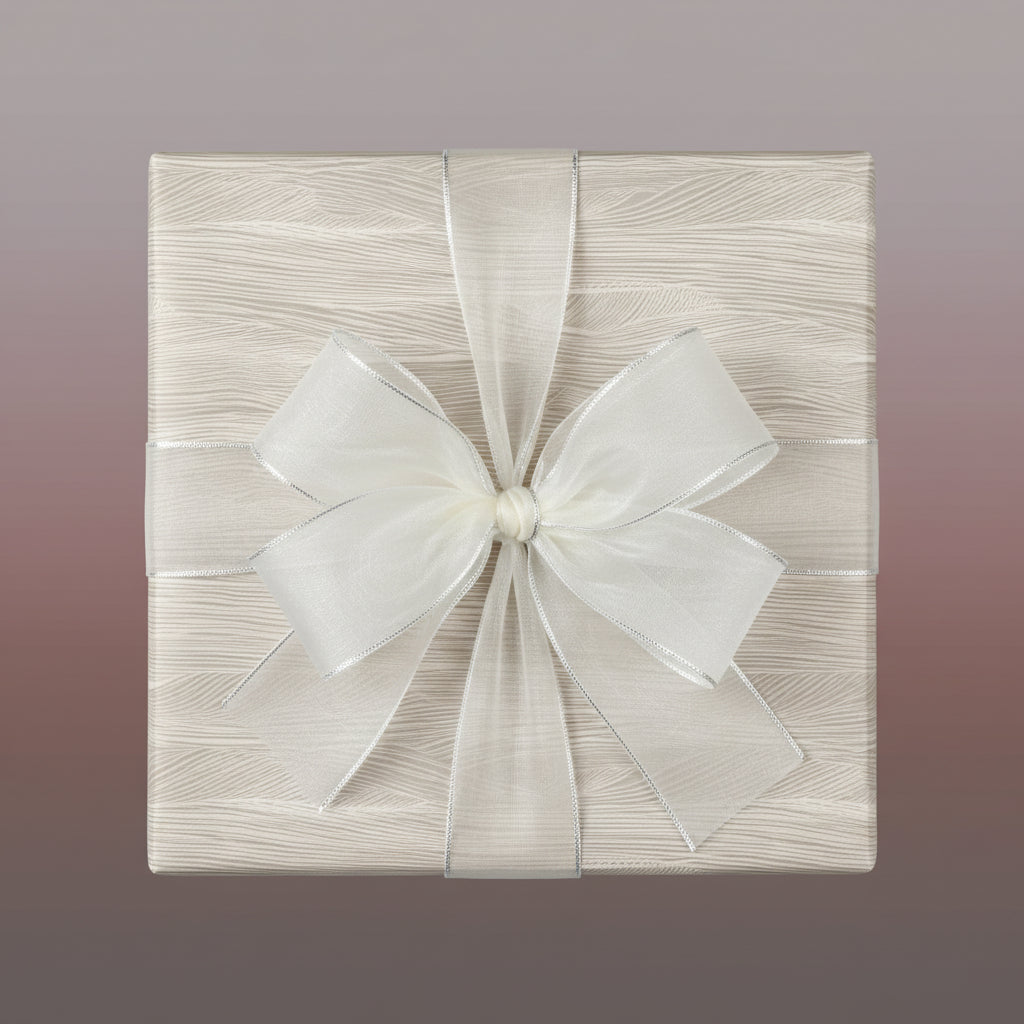Elegant gift wrapped in beige woodgrain paper with sheer white ribbon and silver trim.