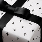 Minimalist black and white wrapping paper with plus pattern and satin bow by Wrapped Studios.