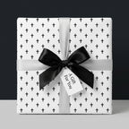 Elegant Christian cross wrapping paper with a black satin bow for baptism, by Wrapped Studios.