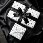 Luxury black and white cross wrapping paper with elegant satin bows by Wrapped Studios.