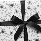Elegant black and white floral wrapping paper tied with a sleek black satin ribbon, perfect for any special occasion gift.