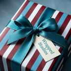 Luxury striped wrapping paper in burgundy, blue, and white with a teal satin bow by Wrapped Studios.