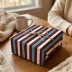 Rustic striped holiday wrapping paper in burgundy and teal with a twine bow, by Wrapped Studios.