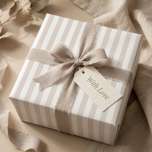 Elegant neutral striped gift wrap with a taupe linen bow and "With Love" tag from Wrapped Studios.
