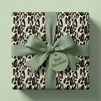 Sage green leopard print wrapping paper with a matching bow and 'Just Because' tag by Wrapped Studios.