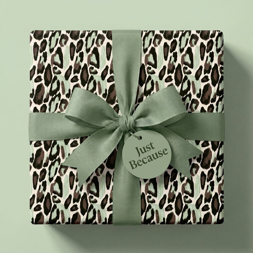 Sage green leopard print wrapping paper with a matching bow and 'Just Because' tag by Wrapped Studios.