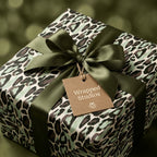 Luxury green leopard print wrapping paper with an olive satin bow and tag from Wrapped Studios.