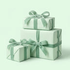 Three mint cream gift boxes with green ribbons on a light green background