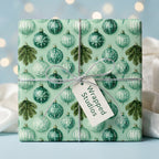 Elegant mint green Christmas wrapping paper with vintage ornaments and silver bow, by Wrapped Studios.