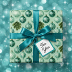 Teal ornament Christmas wrapping paper with a matching satin ribbon bow on a gift box, by Wrapped Studios.