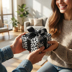 Modern black and white abstract gift wrap with a black bow being exchanged in a cozy home setting.