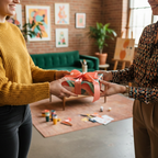 Woman exchanging a birthday gift wrapped in modern, colorful wrapping paper with a coral ribbon.