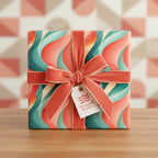 Square gift box in colorful retro wave wrapping paper with coral velvet ribbon and bow.