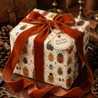 Beetle-themed wrapping paper with an amber velvet ribbon and "For the Curious" tag, from Wrapped Studios.