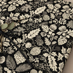 Black & cream floral wrapping paper with black ribbon and berry accent, perfect for elegant Christmas gift wrap or rustic birthday presents.