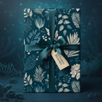 Elegant gift wrapped in dark blue floral wrapping paper with teal ribbon and "Oceanic Blooms" tag.