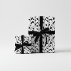Two gifts wrapped in botanical wrapping paper with black velvet ribbon from Wrapped Studios.
