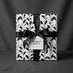Elegant gift with black ribbon and Wrapped Studios floral wrapping paper.