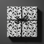 Elegant gift wrapped in black and white floral wrapping paper with a black twine bow.