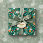 Square gift wrapped in green floral wrapping paper with olive ribbon and "Warmest Wishes" tag.