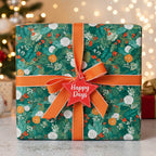Elegant Christmas gift wrapped in green floral paper with an orange ribbon and a Happy Days tag.