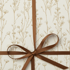 Elegant floral wrapping paper with a brown satin ribbon tied in a bow.