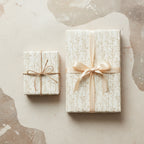 Elegant gifts wrapped in floral wrapping paper with cream ribbon and twine, perfect for birthdays or special occasions.