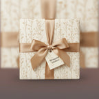 Elegant gift wrapped in floral wrapping paper with a gold satin bow.