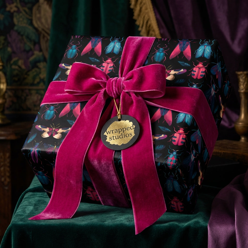 Luxury gift wrap with a beetle print and pink velvet ribbon, perfect for birthdays or special occasions.
